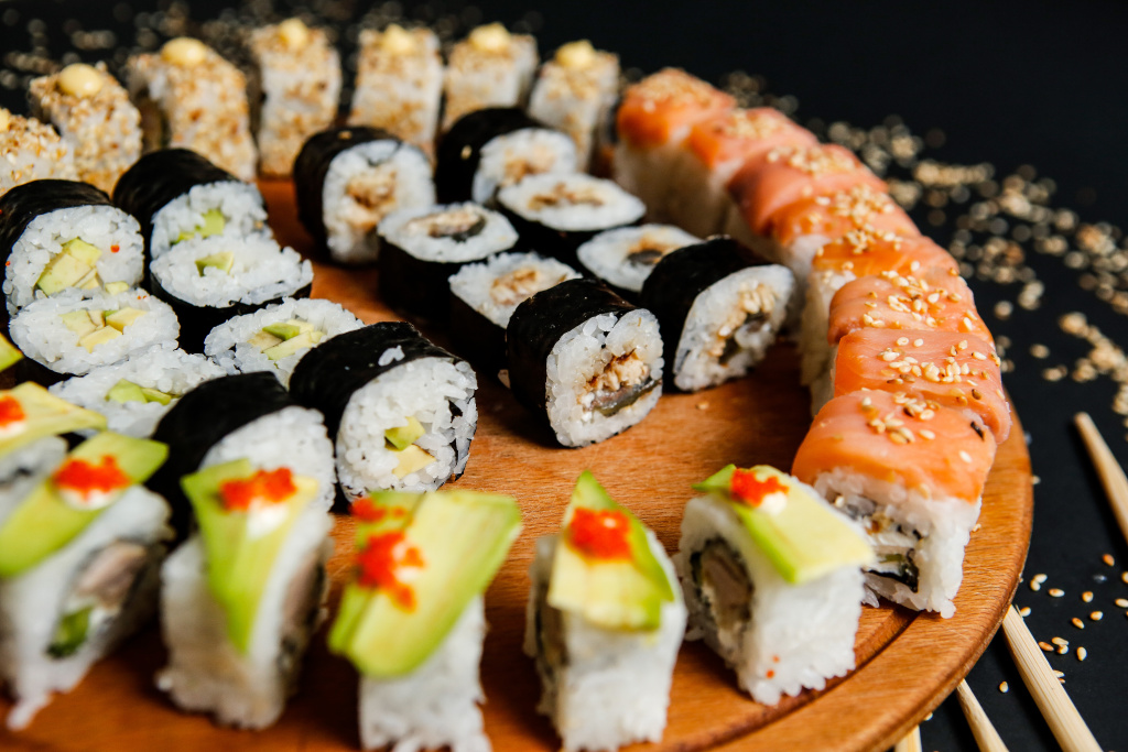 side-view-mix-sushi-rolls-with-avocado-sesame-seeds-chopsticks-stand.jpg